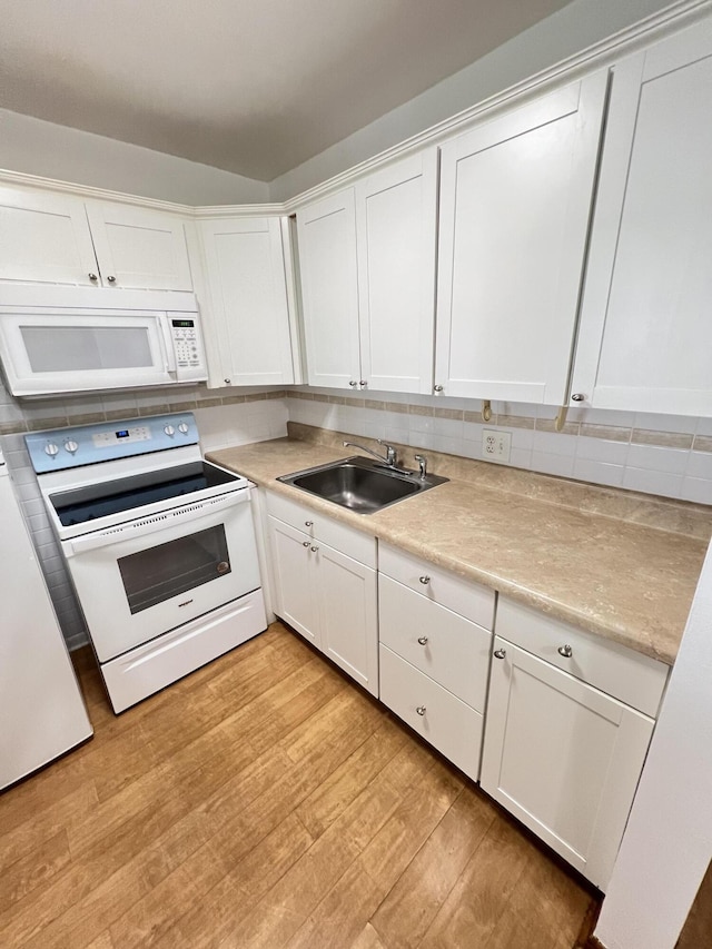 kitchen featuring white cabinetry, sink, white appliances, and light hardwood / wood-style floors