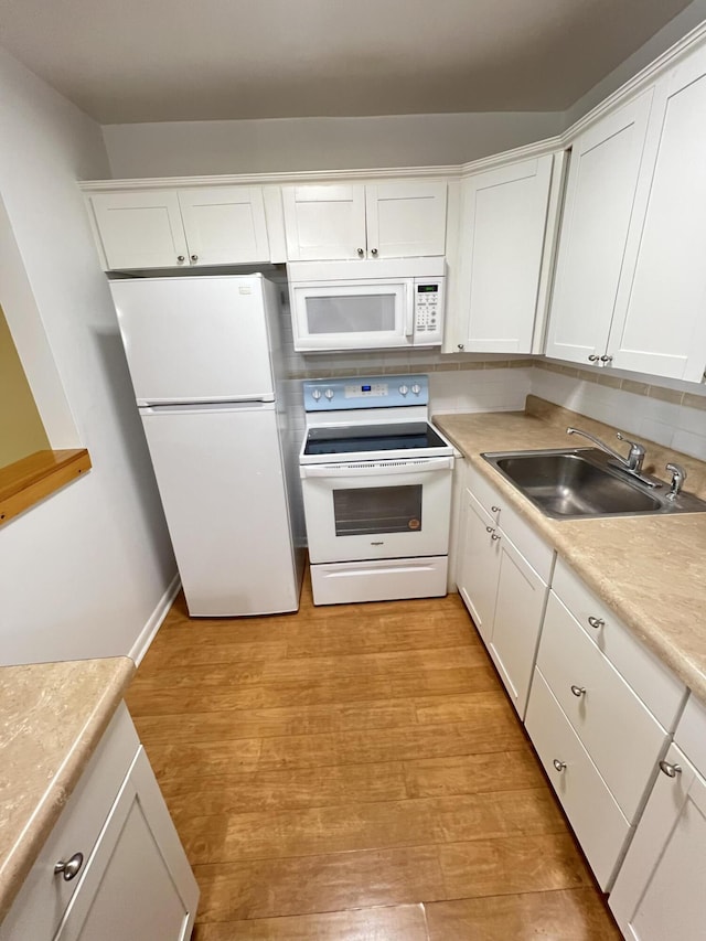 kitchen with sink, white appliances, light hardwood / wood-style flooring, white cabinetry, and tasteful backsplash