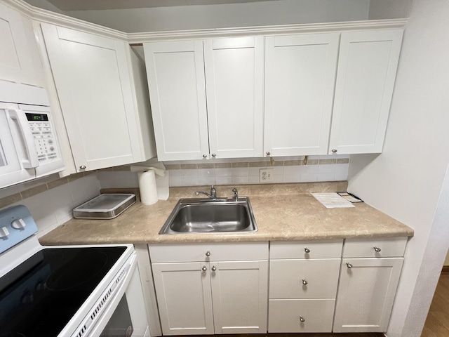 kitchen with white cabinetry, white appliances, sink, and backsplash