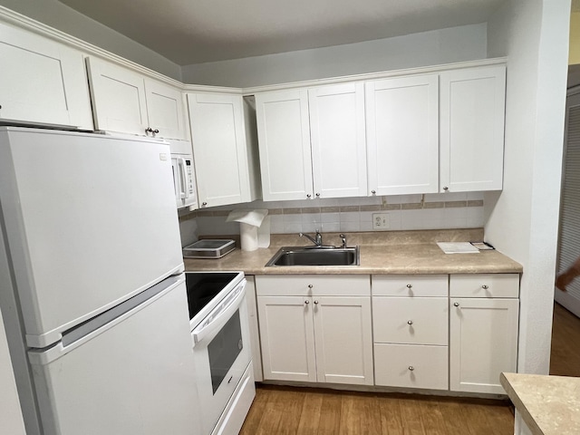 kitchen with sink, white appliances, white cabinets, decorative backsplash, and light wood-type flooring