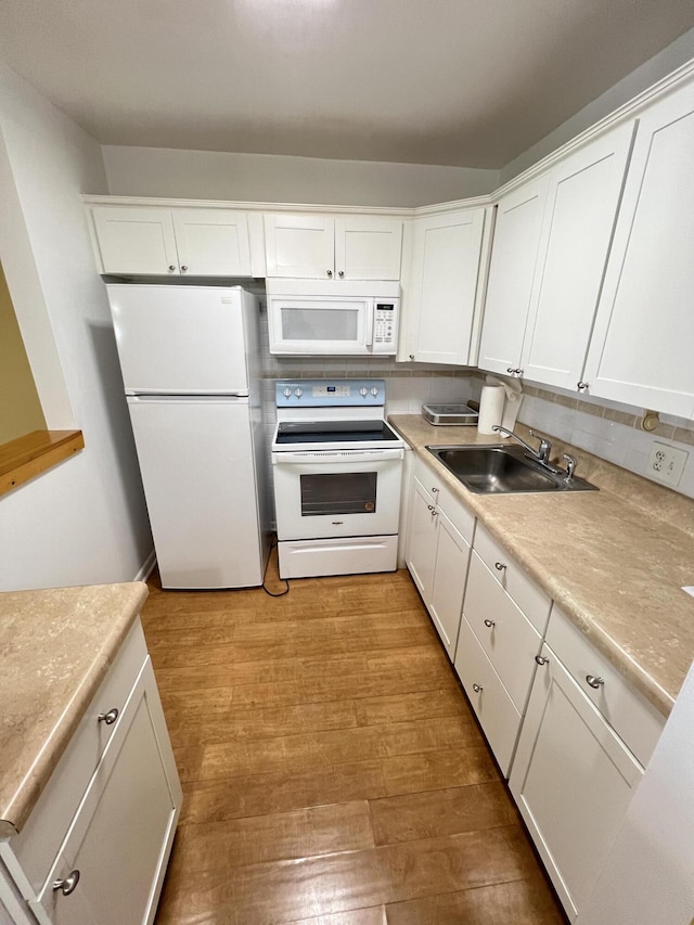 kitchen featuring sink, white appliances, light hardwood / wood-style flooring, white cabinets, and decorative backsplash