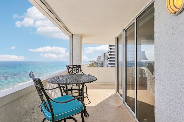 balcony with a water view and a beach view