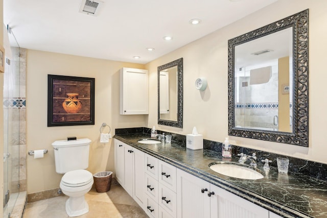 bathroom with tile patterned flooring, vanity, an enclosed shower, and toilet