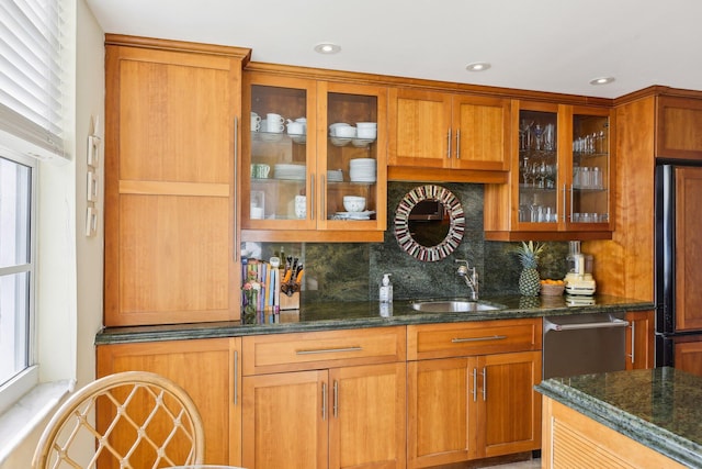 kitchen featuring tasteful backsplash, sink, paneled fridge, and dark stone counters