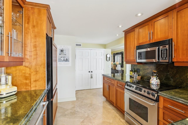 kitchen with backsplash, dark stone counters, and appliances with stainless steel finishes