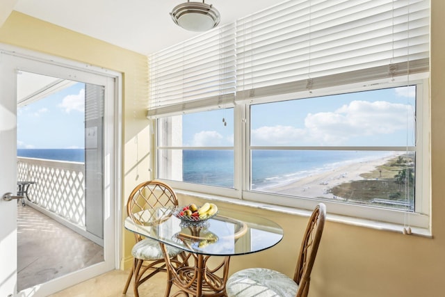 sunroom featuring a view of the beach and a water view