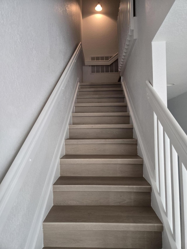 stairs featuring a textured wall