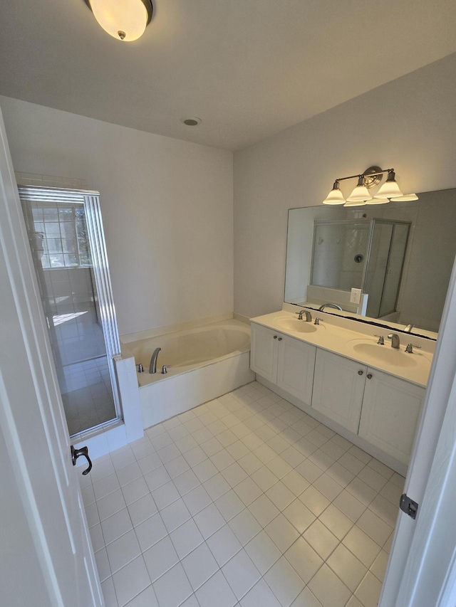 bathroom with double vanity, a sink, a bath, and tile patterned floors