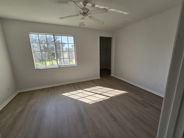 empty room with dark wood-type flooring and baseboards