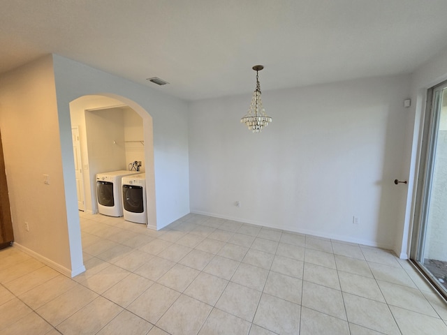 interior space with light tile patterned floors, arched walkways, visible vents, independent washer and dryer, and an inviting chandelier