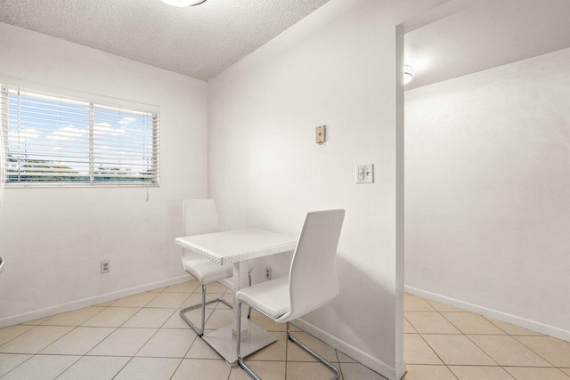 tiled dining room with a textured ceiling