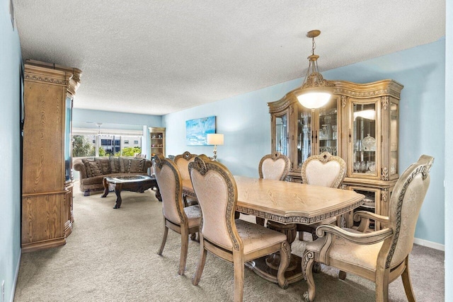 carpeted dining room featuring a textured ceiling