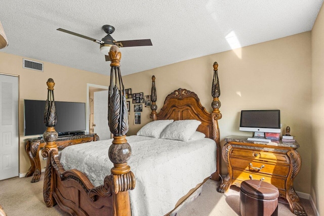 carpeted bedroom featuring a textured ceiling and ceiling fan