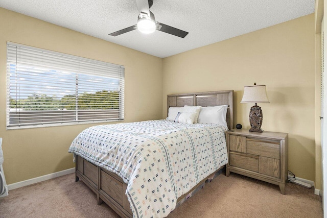 carpeted bedroom with ceiling fan and a textured ceiling