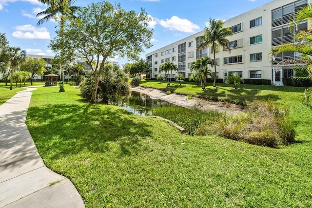 view of home's community with a lawn and a water view