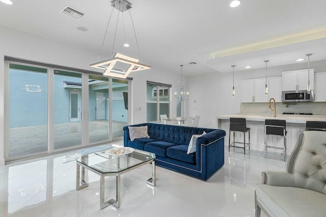 living room with sink and a notable chandelier