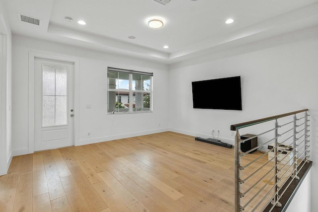 foyer with a raised ceiling and hardwood / wood-style floors