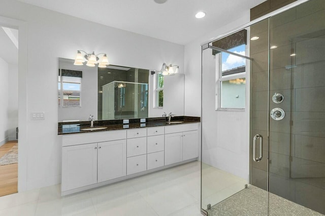 bathroom featuring vanity and a shower with door