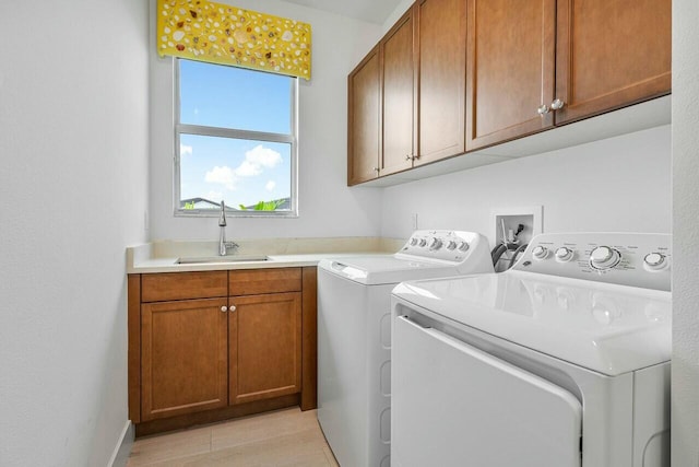 laundry area with separate washer and dryer, sink, and cabinets