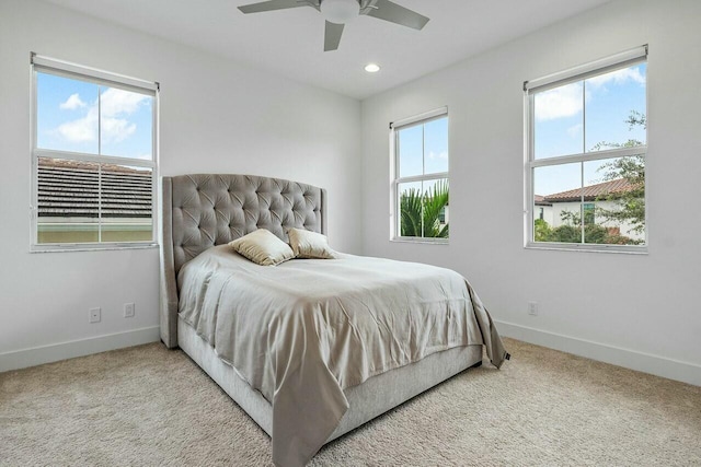 carpeted bedroom featuring ceiling fan and multiple windows