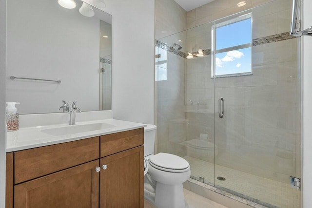 bathroom with vanity, an enclosed shower, and toilet