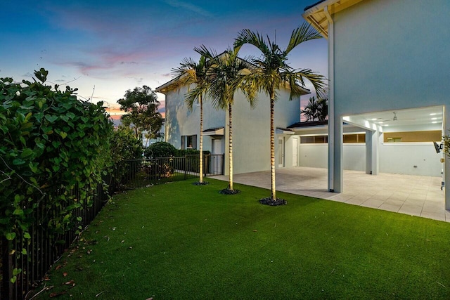 yard at dusk featuring a patio