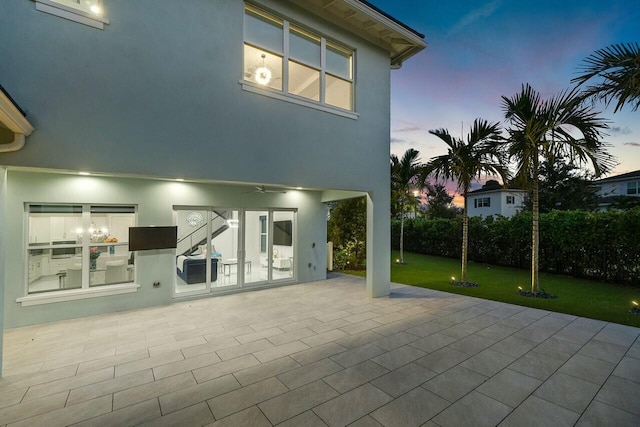 back house at dusk with a patio area