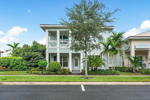 view of front of home featuring a balcony and a front yard