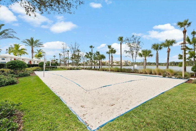 view of home's community featuring a water view, volleyball court, and a lawn