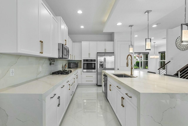 kitchen featuring a large island, hanging light fixtures, white cabinets, and appliances with stainless steel finishes