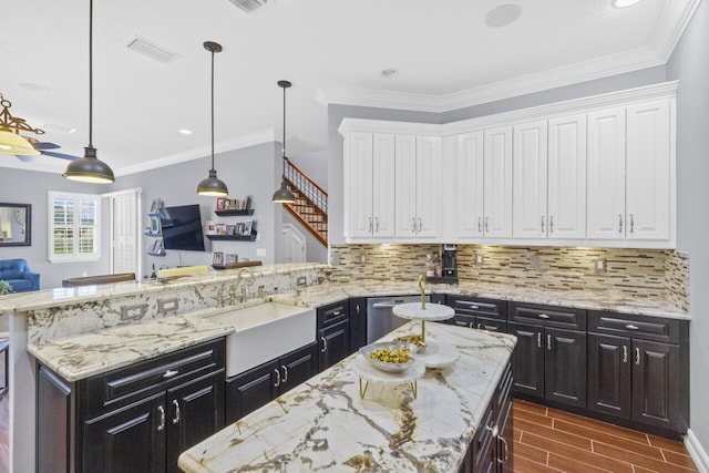 kitchen featuring white cabinetry, sink, hanging light fixtures, and a kitchen island