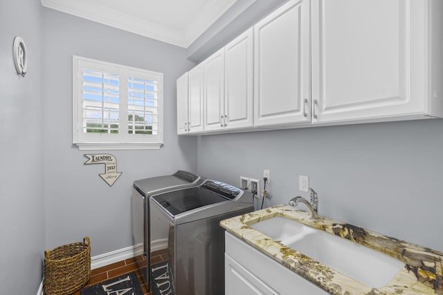 clothes washing area with cabinets, crown molding, sink, and independent washer and dryer