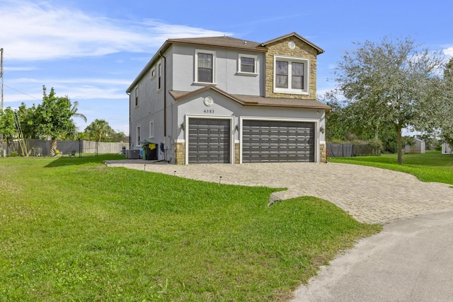 view of front facade featuring a garage, central AC, and a front yard