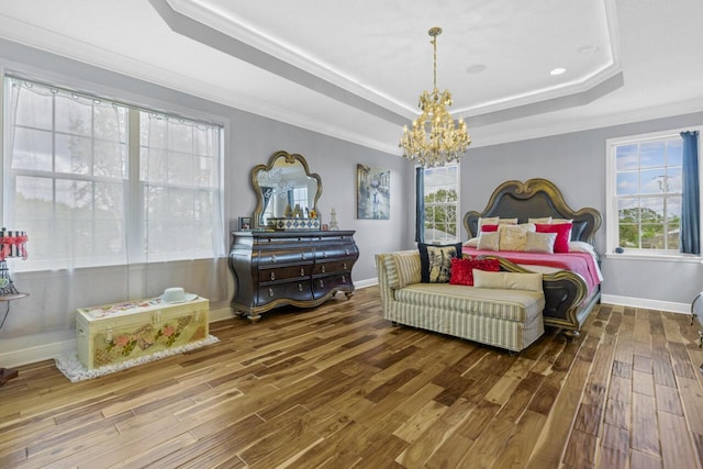 bedroom with a raised ceiling, crown molding, hardwood / wood-style flooring, and an inviting chandelier