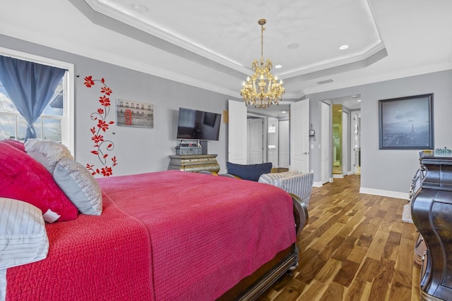 bedroom featuring dark hardwood / wood-style flooring, a notable chandelier, crown molding, and a raised ceiling