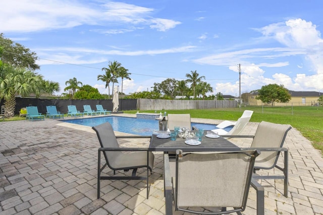 view of pool with a patio and a lawn