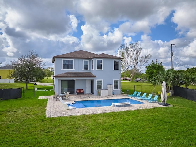 back of house with a swimming pool with hot tub, a lawn, and a patio area