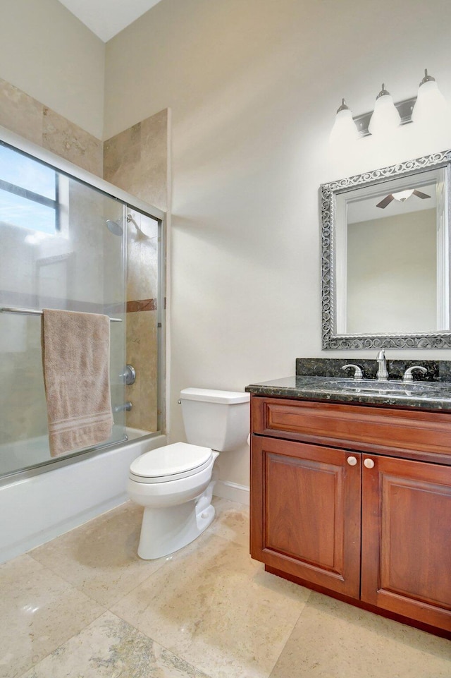 full bathroom featuring ceiling fan, bath / shower combo with glass door, vanity, tile patterned floors, and toilet