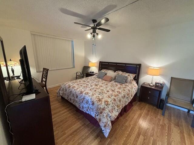 bedroom featuring ceiling fan, dark wood-type flooring, and a textured ceiling