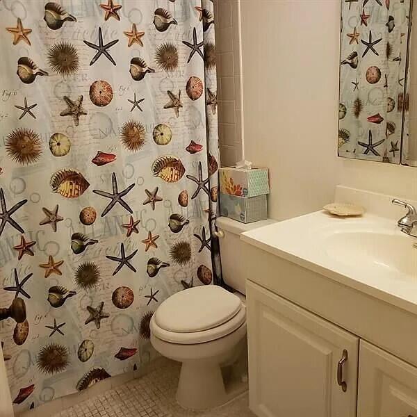 bathroom with tile patterned floors, vanity, toilet, and curtained shower