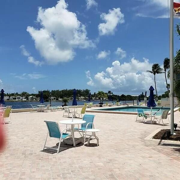 view of swimming pool featuring a water view and a patio area