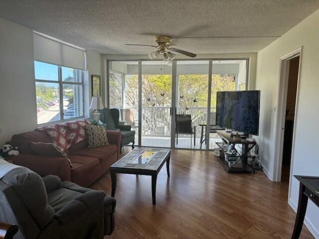 living room with hardwood / wood-style floors, a textured ceiling, and ceiling fan