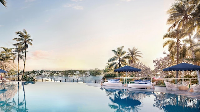 pool at dusk featuring a water view