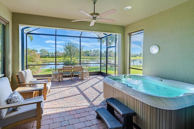 sunroom / solarium with a jacuzzi and a water view