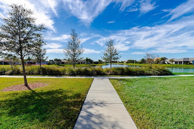 view of community with a water view and a lawn