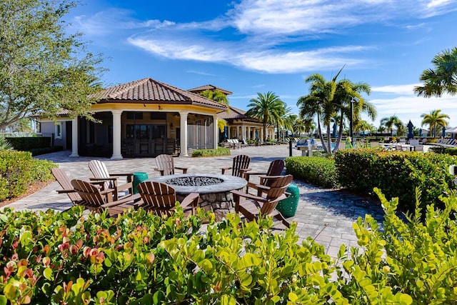 view of community featuring a patio and an outdoor fire pit