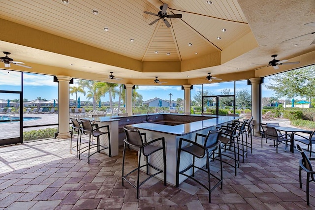 view of patio featuring ceiling fan and exterior bar