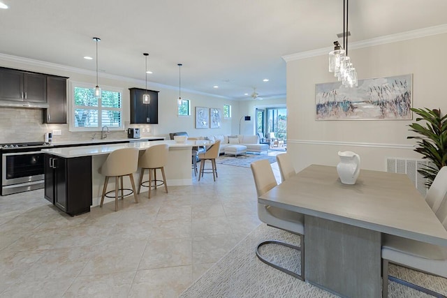 kitchen with ornamental molding, tasteful backsplash, stainless steel range oven, and a wealth of natural light