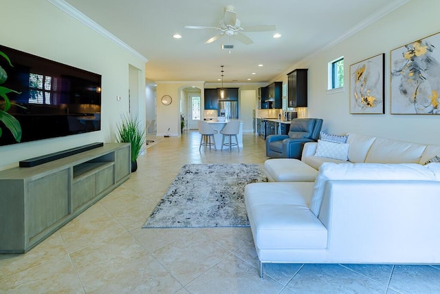 tiled living room with ornamental molding and ceiling fan