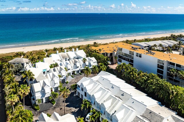 birds eye view of property with a water view and a beach view